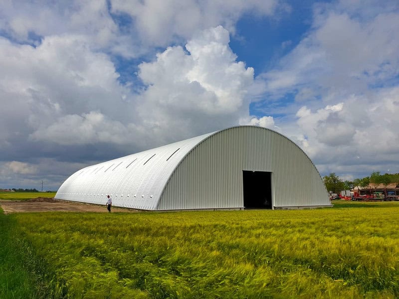 Montovaná ocelová oblouková zemědělská hala postavená na okraji pole, samonosná konstrukce bez vnitřních sloupů, realizace HUPRO SYSTEMS SE.