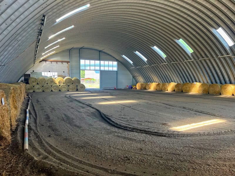 Interiér ocelové obloukové zemědělské haly se skladovanými balíky sena a slámy, realizace HUPRO SYSTEMS SE.