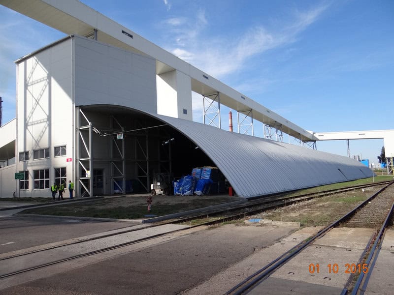 Průmyslová ocelová oblouková hala u železniční vlečky využívaná pro skladování materiálu. Realizace HUPRO SYSTEMS SE.