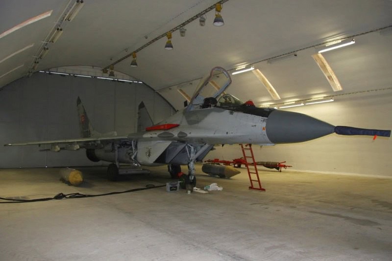 Oblouková ocelová montovaná armádní hala s vojenským letounem uvnitř, odolný hangár HUPRO SYSTEMS SE