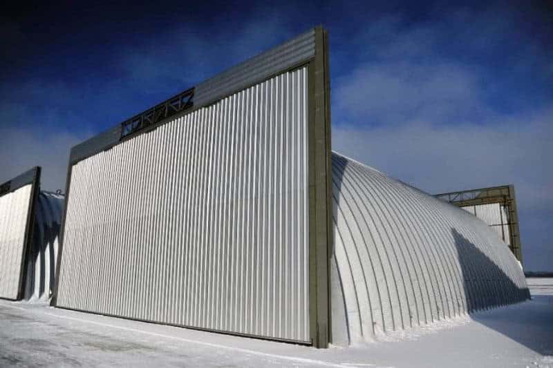 Obloukové ocelové montované armádní haly se zavřenými vraty v zasněženém prostředí, samonosná konstrukce HUPRO SYSTEMS SE
