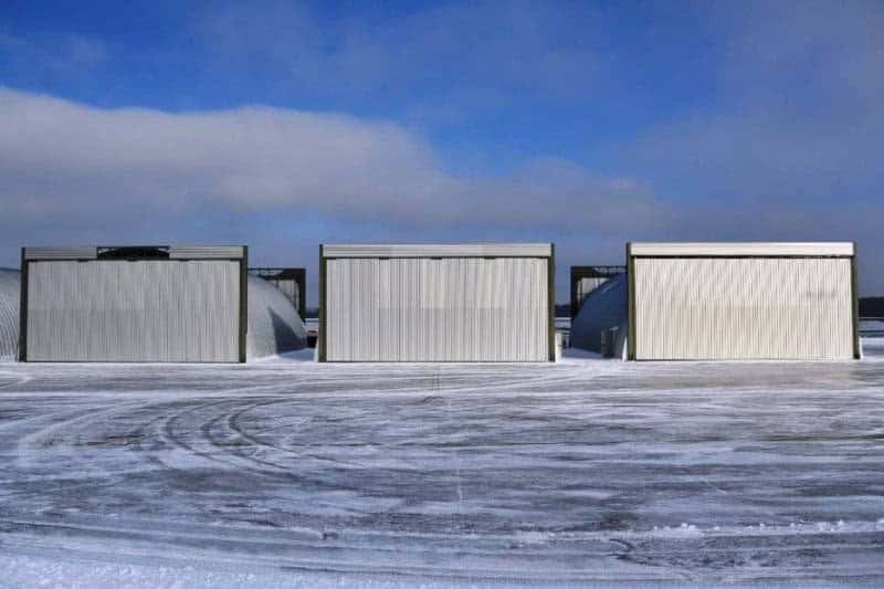 Obloukové ocelové montované armádní haly se zavřenými vraty na zasněženém letišti, samonosná konstrukce HUPRO SYSTEMS SE