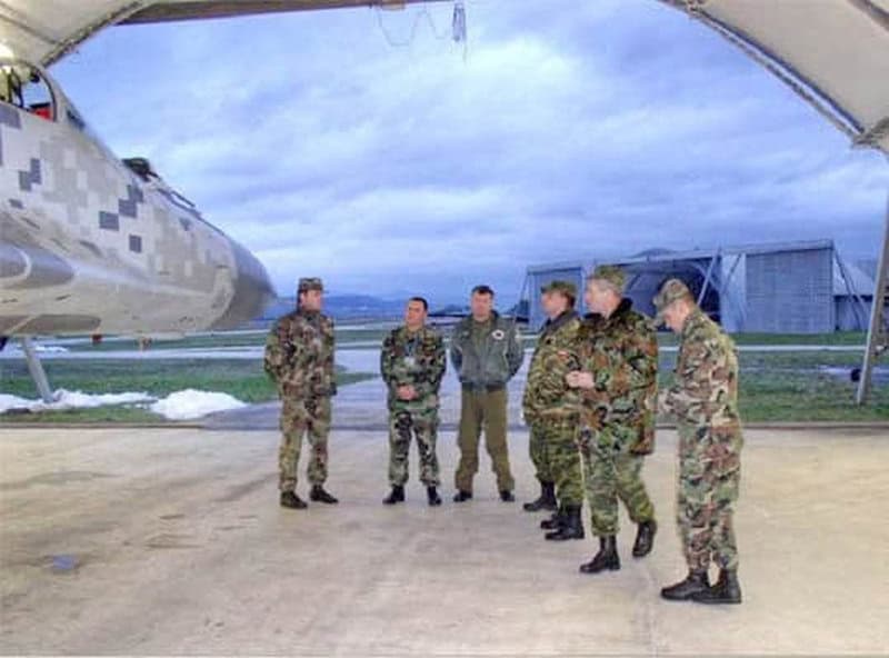 Oblouková ocelová montovaná armádní hala se skupinou vojáků u letounu, armádní letecká základna, realizace HUPRO SYSTEMS SE