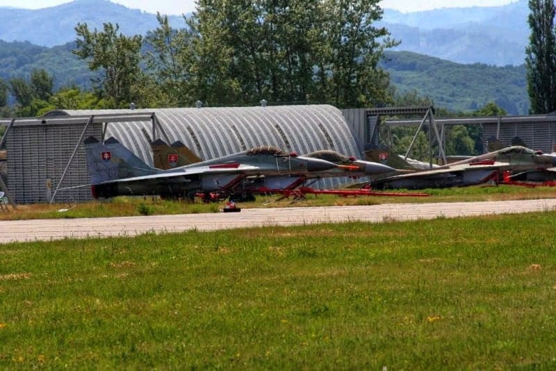 Obloukové ocelové montované armádní haly na letišti s vojenskými letouny před hangárem, realizace HUPRO SYSTEMS SE