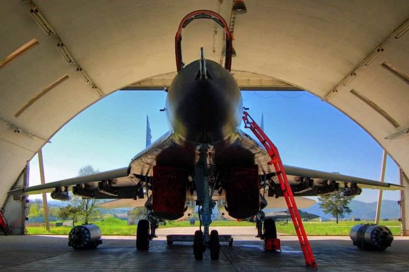 Oblouková ocelová montovaná armádní hala využívaná pro leteckou techniku, uvnitř stojí vojenské letadlo, realizace HUPRO SYSTEMS SE