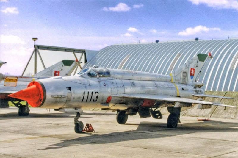 Oblouková ocelová montovaná armádní hala s vojenským letounem před hangárem, odolná konstrukce HUPRO SYSTEMS SE