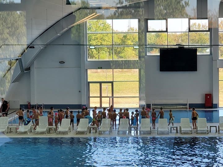 Montovaná ocelová plavecká hala Lajkovac – interiér s bazénem a dětmi při výuce plavání, realizace HUPRO SYSTEMS SE.