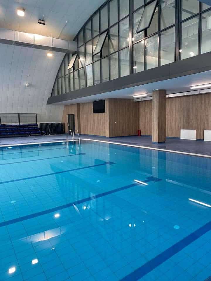 Montovaná ocelová plavecká hala Novi Pazar – detail interiéru krytého bazénu s prosklenou galerií a moderními obklady stěn, realizace HUPRO SYSTEMS SE.