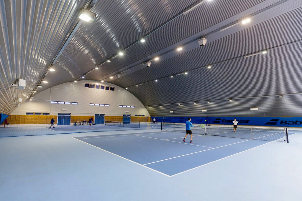Oblouková sportovní hala Eger, interiér s tenisovými kurty a moderním LED osvětlením, realizace HUPRO SYSTEMS SE.