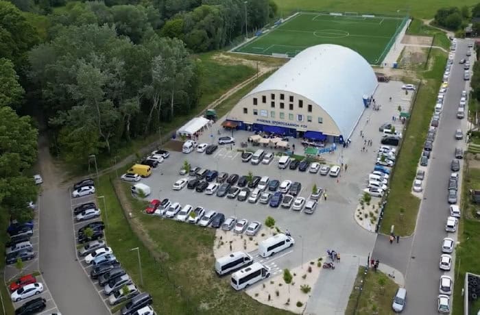 Montovaná ocelová sportovní hala Fót Phoenix Sportcsarnok, letecký pohled na basketbalovou halu s parkovištěm a venkovním hřištěm, realizace HUPRO SYSTEMS SE.