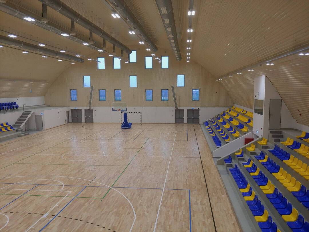 Moderní oblouková sportovní hala Fót s tribunou a multifunkčním hřištěm pro halové sporty, realizace HUPRO SYSTEMS SE.