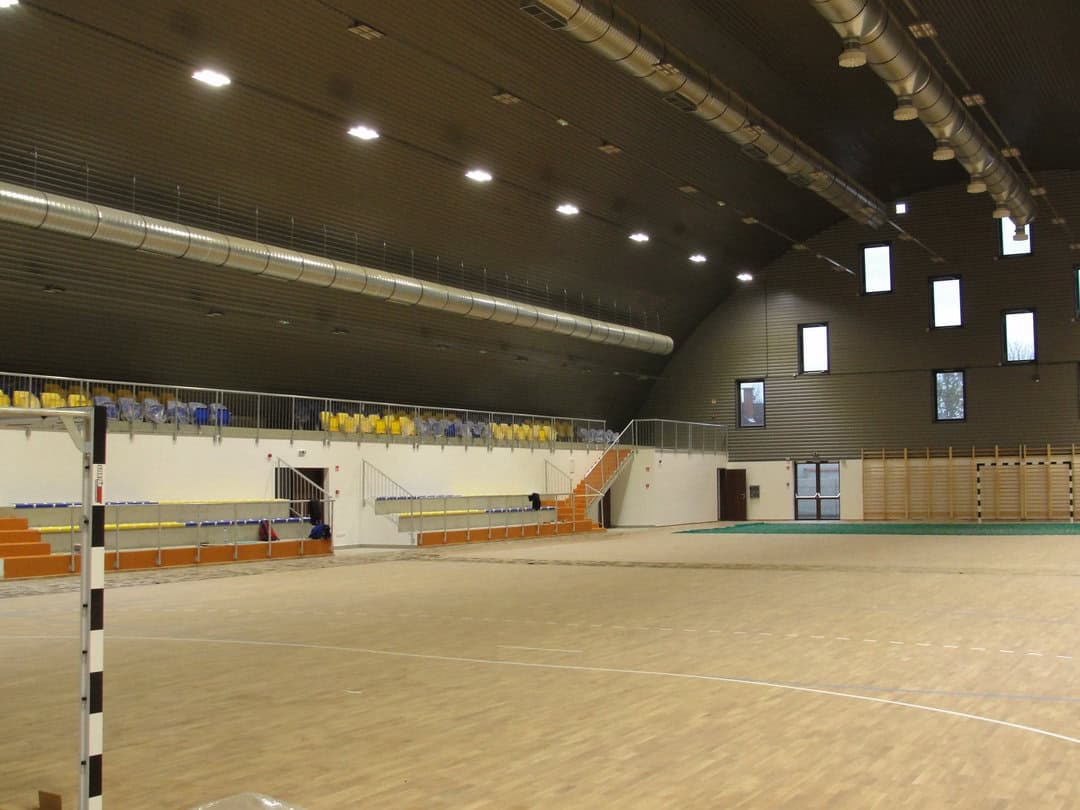 Oblouková sportovní hala Hajdúnánás s tribunou a hrací plochou pro házenou, realizace HUPRO SYSTEMS SE.
