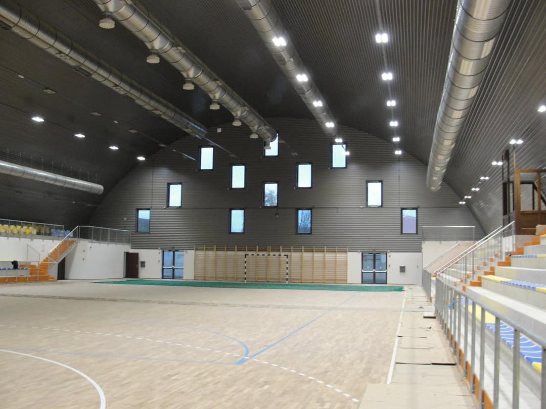 Montovaná ocelová sportovní hala Hajdúnánás Hódos Imre Sportcsarnok, interiér s hrací plochou pro házenou, samonosná konstrukce HUPRO SYSTEMS SE.