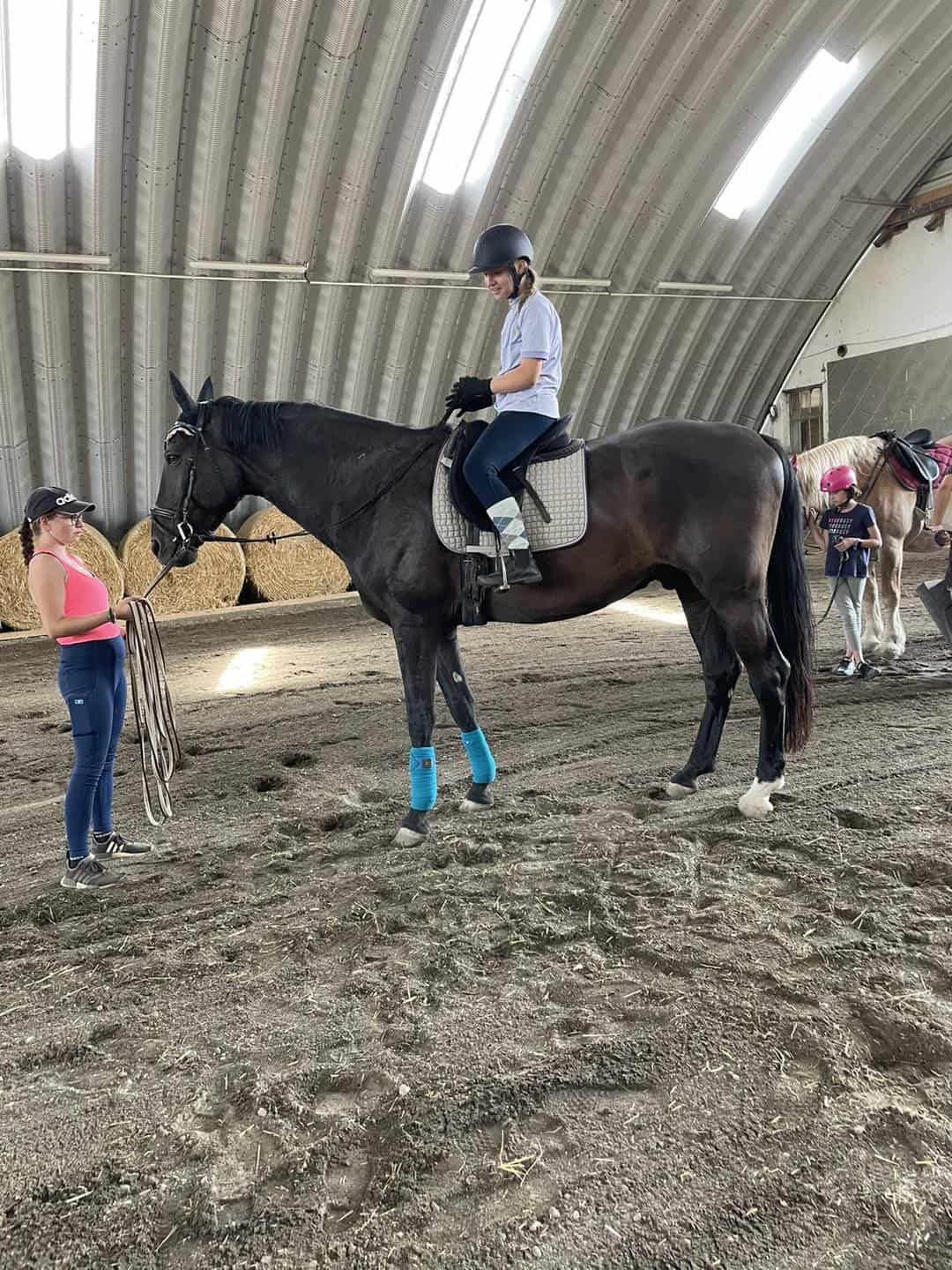 Instruktorka a jezdkyně během tréninku v jízdárně v Břeclavi, která se nachází v obloukové ocelové hale. Realizace HUPRO SYSTEMS SE.