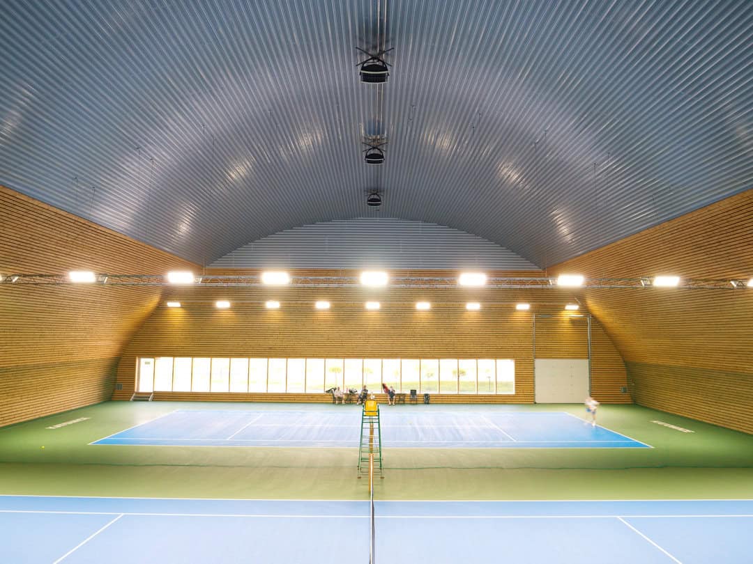 Celkový pohled od kurtu na interiér montované obloukové ocelové tenisové haly v Katowicích – realizovala společnost HUPRO SYSTEMS SE.