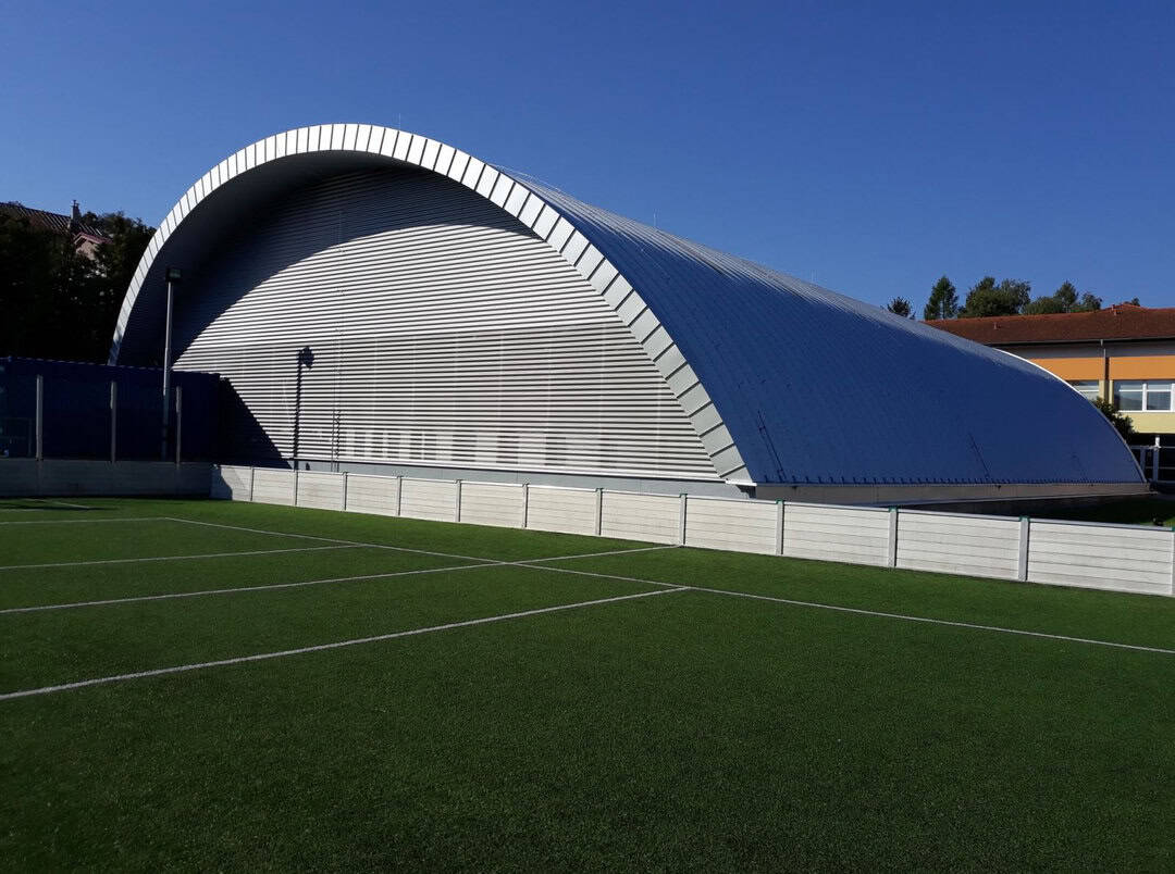 Moderní oblouková sportovní hala Pelikán v Hanušovcích nad Topľou s přilehlým sportovním hřištěm, postavená systémem HUPRO SYSTEMS SE.