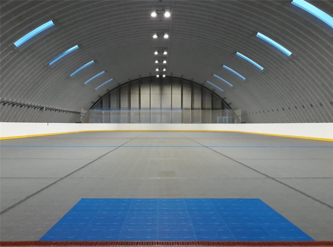 Moderní interiér obloukové sportovní haly Pelikán v Hanušovcích nad Topľou s multifunkčním povrchem pro florbal a další halové sporty, postavené systémem HUPRO SYSTEMS SE.