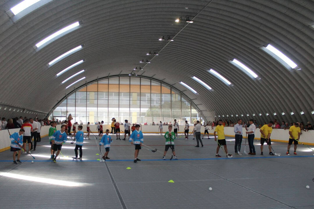 Interiér moderní obloukové sportovní haly Pelikán v Hanušovcích nad Topľou během florbalového turnaje mládeže, postavené systémem HUPRO SYSTEMS SE.