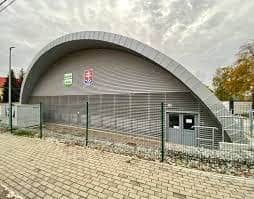 Exteriér multifunkční sportovní haly v Lipanech s moderní obloukovou ocelovou konstrukcí a vstupní fasádou, postavené systémem HUPRO SYSTEMS SE.