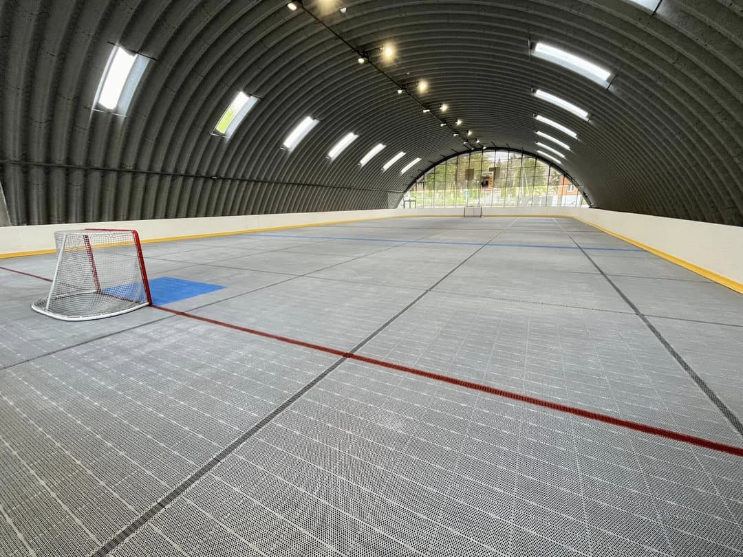 Interiér multifunkční sportovní haly v Lipanech s plastovým povrchem pro hokejbal a další halové sporty, oblouková ocelová konstrukce postavená systémem HUPRO SYSTEMS SE.