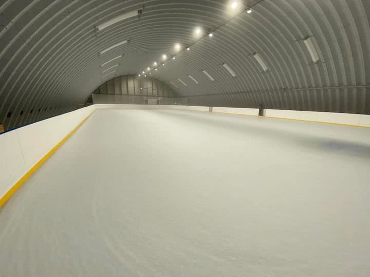 Interiér multifunkční sportovní haly v Lipanech s ledovou plochou pro hokej a bruslení, moderní oblouková ocelová konstrukce postavená systémem HUPRO SYSTEMS SE.