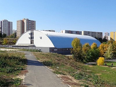 Moderní hokejová hala HUPRO Aréna v Nitře – Klokočině s montovanou konstrukcí od společnosti HUPRO SYSTEMS SE, zasazená do městské zástavby mezi sídlištěmi.