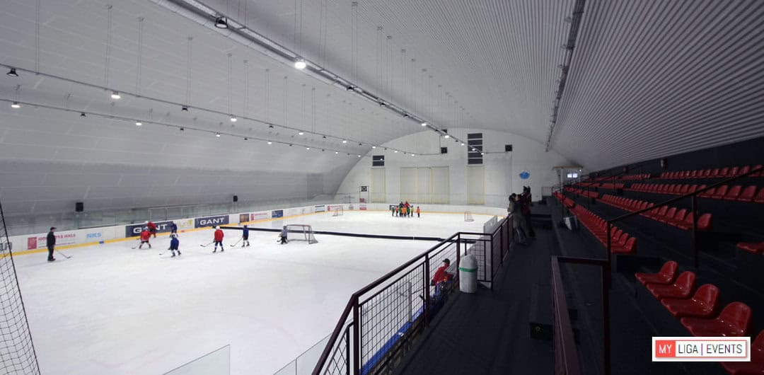 Interiér hokejové haly HUPRO Aréna v Nitře – Klokočině s ledovou plochou, hráči během tréninku a tribunami pro diváky, montovaná konstrukce od společnosti HUPRO SYSTEMS SE.