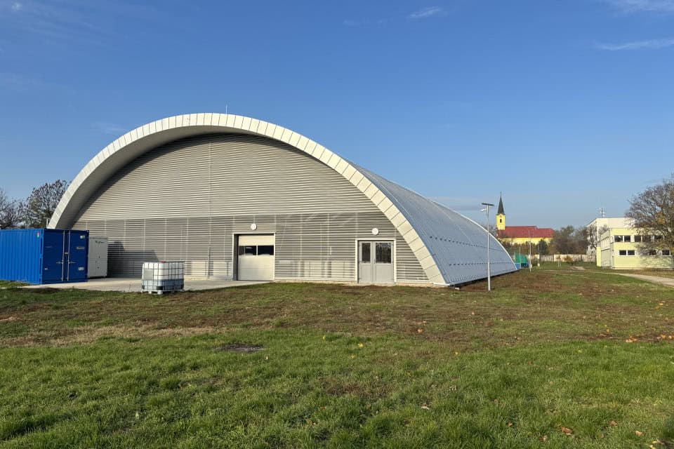 Denní pohled na obloukovou montovanou ocelovou sportovní halu Šoporňa s ledovou plochou, postavenou systémem HUPRO SYSTEMS SE