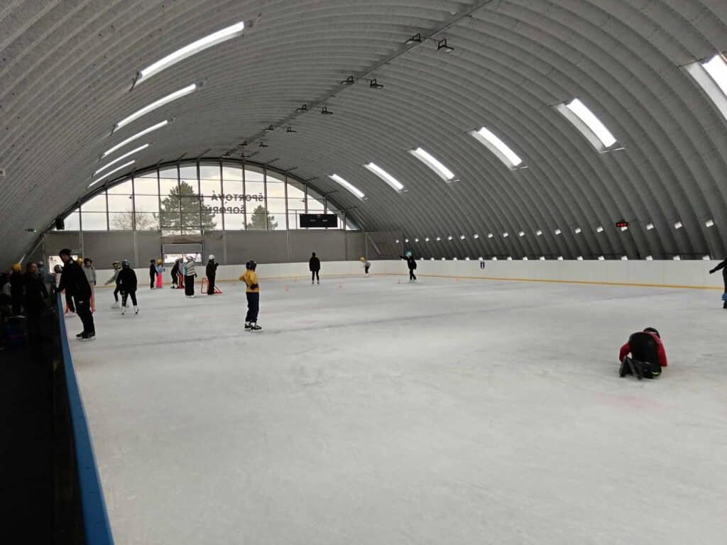 Vnitřní pohled na obloukovou montovanou ocelovou halu v Šoporni, která slouží jako zimní kluziště, postavenou systémem HUPRO SYSTEMS SE.