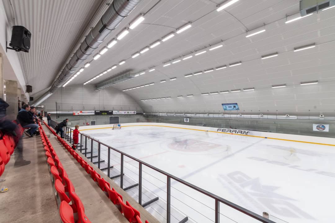 Zimní stadion Telč – pohled z tribuny na ledovou plochu v moderní obloukové montované ocelové hale, projekt realizovaný firmou HUPRO SYSTEMS SE.