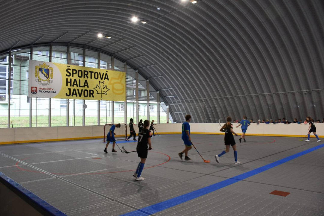 Florbalový zápas mladých sportovců ve sportovní hale Javor v Tvrdošíně, moderní oblouková ocelová hala s multifunkční hrací plochou postavená systémem HUPRO SYSTEMS SE.