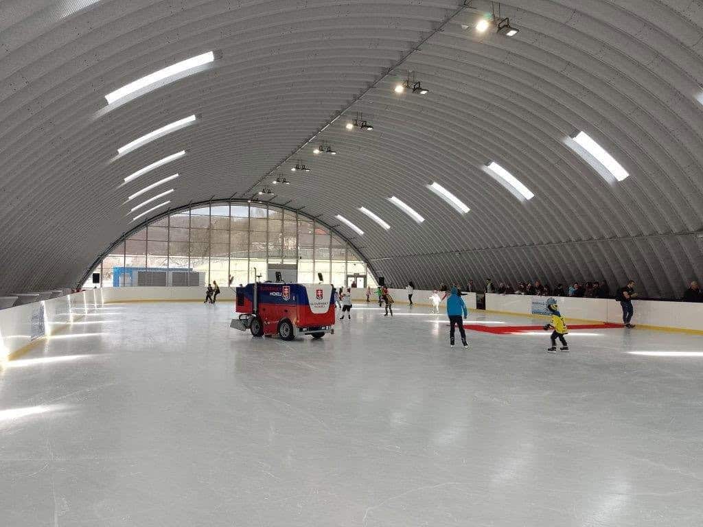 Interiér sportovní haly Javor v Tvrdošíně s ledovou plochou během bruslení veřejnosti, oblouková ocelová hala postavená systémem HUPRO SYSTEMS SE.