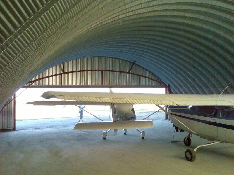 Oblouková ocelová montovaná letecká hala s lehkými letadly zaparkovanými uvnitř, samonosná konstrukce HUPRO SYSTEMS SE