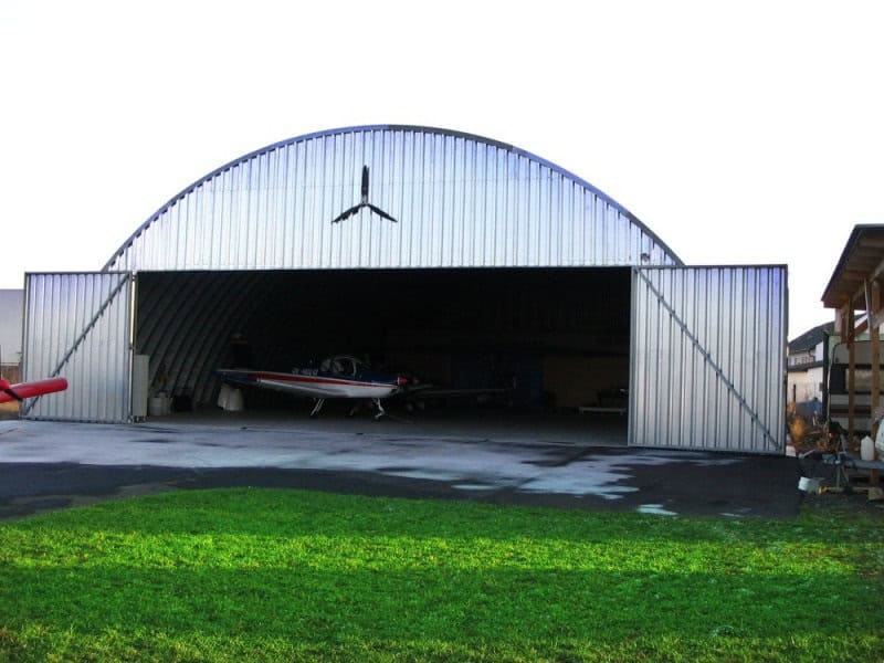 Oblouková ocelová montovaná letecká hala s letadlem uvnitř, samonosná konstrukce HUPRO SYSTEMS SE