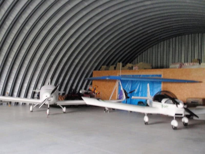 Oblouková ocelová montovaná letecká hala s malými letadly uvnitř, realizace HUPRO SYSTEMS SE