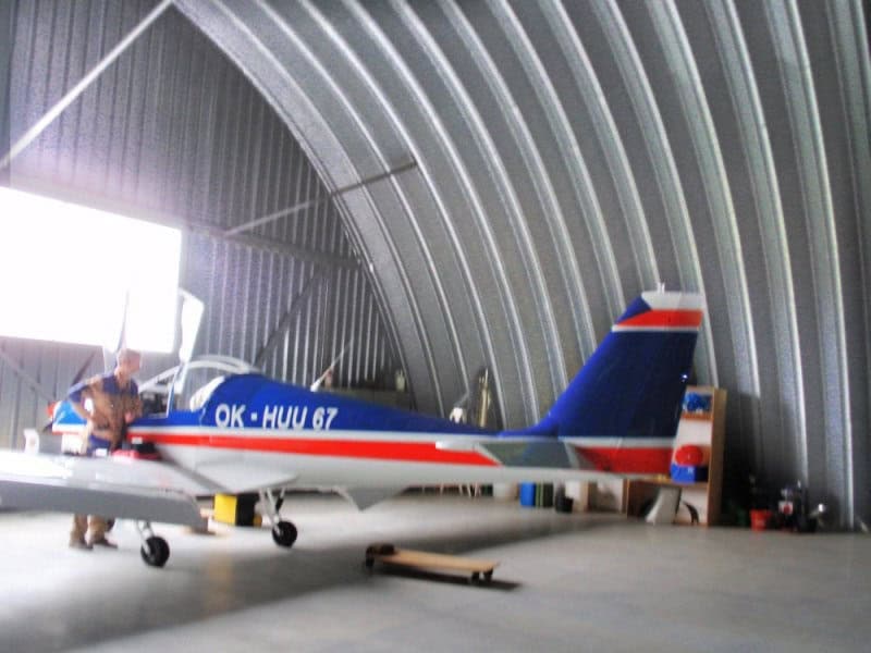 Oblouková ocelová montovaná letecká hala s malým letadlem uvnitř, realizace HUPRO SYSTEMS SE