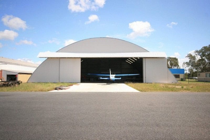 Oblouková ocelová montovaná letecká hala s malým letadlem připraveným na vzlet, samonosná konstrukce HUPRO SYSTEMS SE