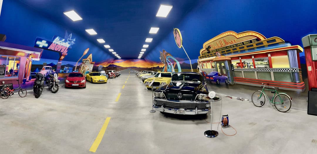 Soukromé muzeum automobilů v hale na zakázku od HUPRO SYSTEMS SE s výmalbou ve stylu Route 66, vystavenými klasickými vozy.