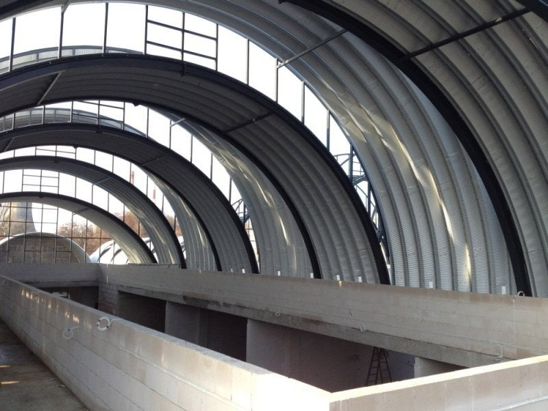 Interiér obloukové ocelové montované haly s viditelnými nosníky a světlíky propouštějícími denní světlo. Realizace HUPRO SYSTEMS SE.