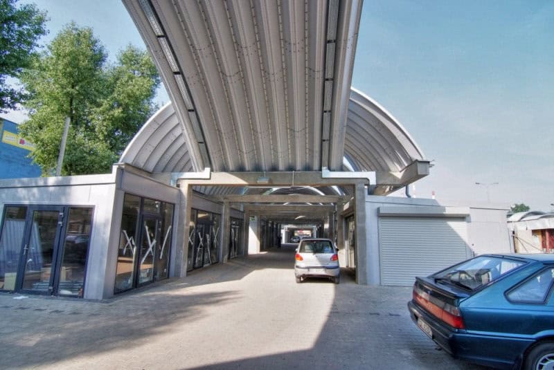 Moderní oblouková ocelová montovaná hala s obchodními jednotkami a parkovací zónou. Realizace HUPRO SYSTEMS SE.