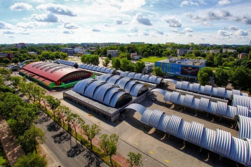 Ocelové montované obloukové haly s moderním designem a červenou střechou, ideální pro komerční a průmyslové využití. Realizace HUPRO SYSTEMS SE.