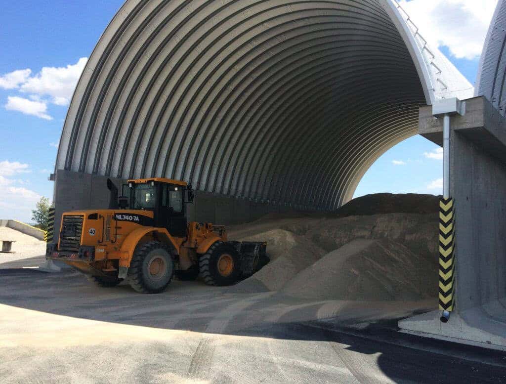 Průmyslová oblouková hala HUPRO SYSTEMS SE s nakladačem Hyundai, sloužící ke skladování sypkých materiálů.