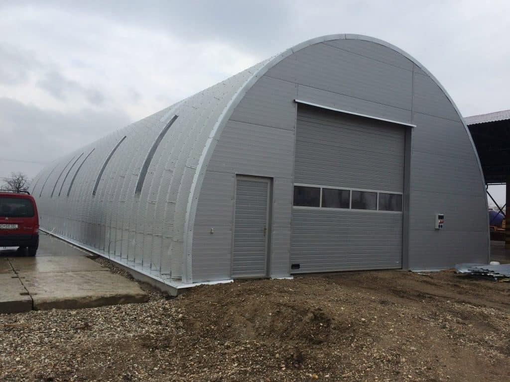 Montovaná ocelová oblouková skladová hala s automatickými vraty v šedém provedení, realizace HUPRO SYSTEMS SE