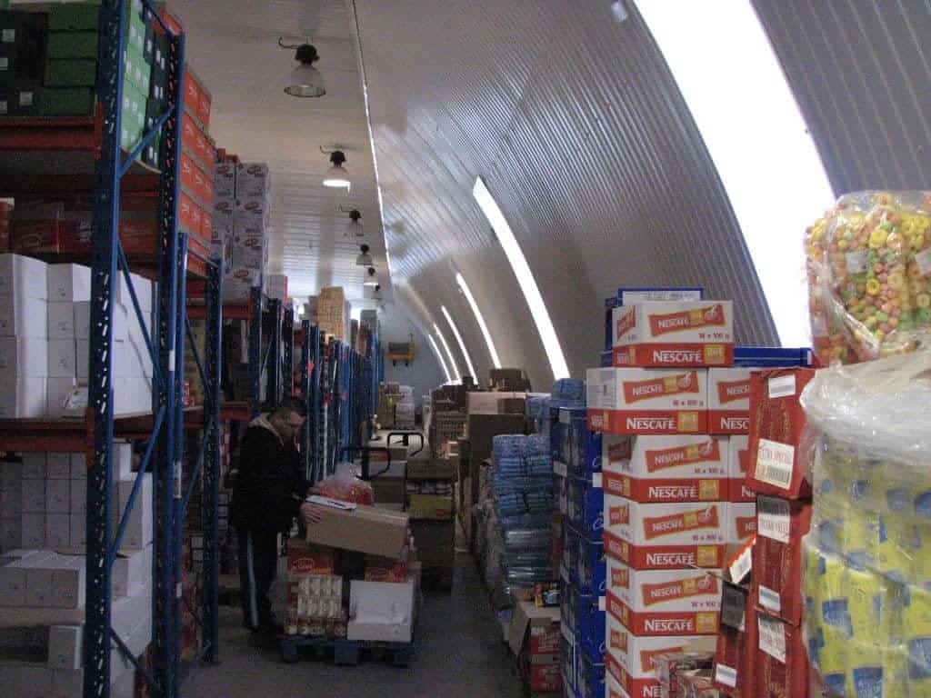 Interiér montované ocelové obloukové haly využívané jako sklad potravin a nápojů s regály a manipulací zboží, realizace HUPRO SYSTEMS SE