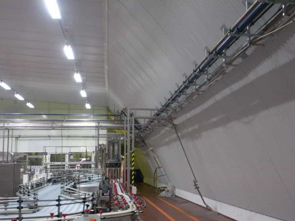 Interiér montované ocelové obloukové průmyslové haly s potrubním systémem a výrobní linkou, realizace HUPRO SYSTEMS SE