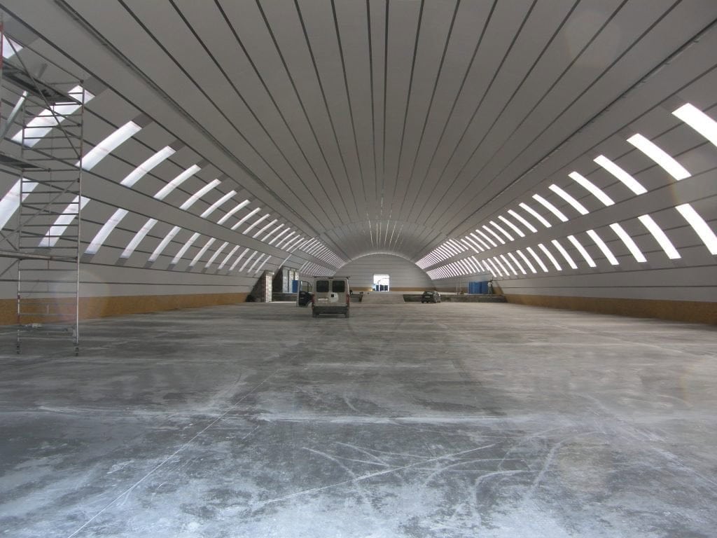 Ocelová oblouková montovaná průmyslová hala, interiér s prosvětlenými stěnami a velkým volným prostorem, realizace HUPRO SYSTEMS SE
