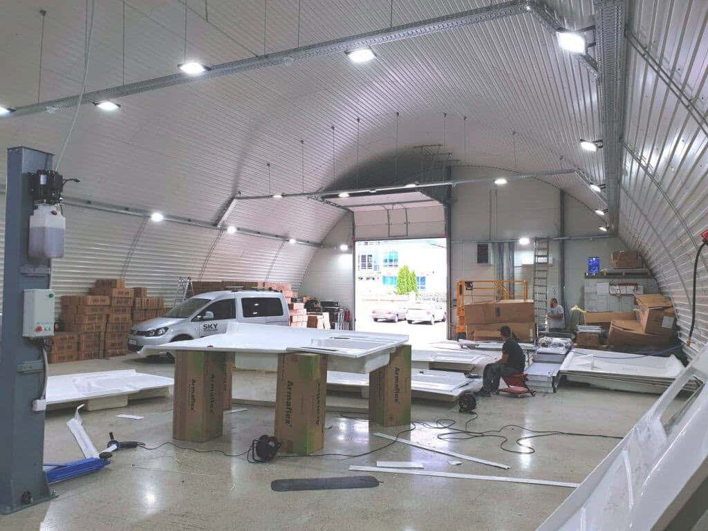 Ocelová oblouková montovaná průmyslová hala využívaná jako servisní a pracovní prostor s vozidly a vybavením, realizace HUPRO SYSTEMS SE