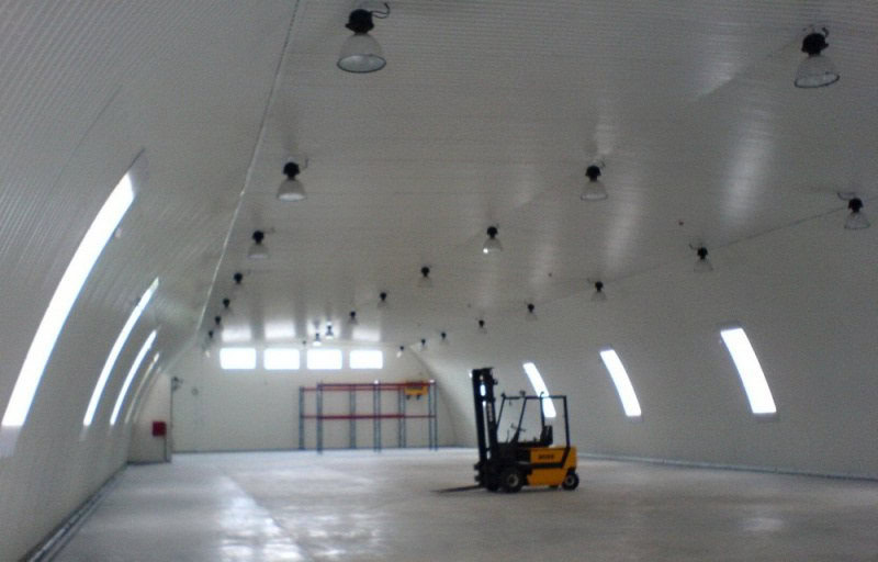 Interiér prázdné ocelové obloukové skladové haly s vysokým stropem a osvětlením, realizace HUPRO SYSTEMS SE