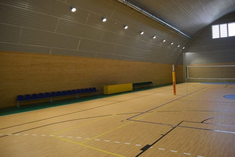 Moderní multifunkční sportovní hala ve městě Bytča na Slovensku s dřevěným obkladem stěn, tribunou a volejbalovým hřištěm od HUPRO SYSTEMS SE.