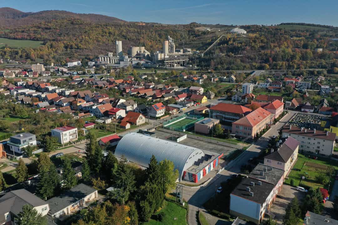 Letecký pohled na město a na obloukovou montovanou ocelovou sportovní halu v Horní Srní postavenou systémem HUPRO SYSTEMS SE